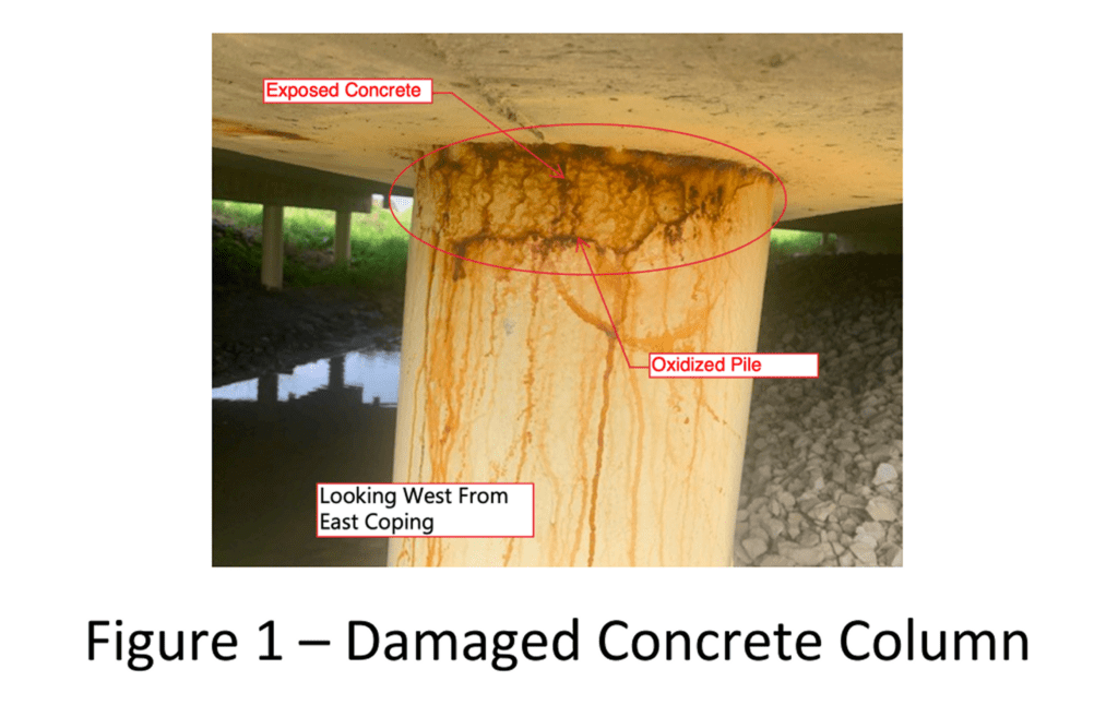 Damaged concrete column with exposed corrosion and vertical cracks.